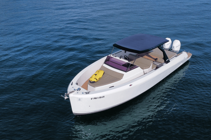 A motorboat with a canopy is floating on a calm blue sea.